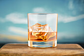 Whisky on the rocks on a wooden table