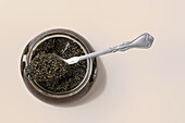 Glass jar with black caviar and spoon