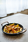 Baked potato wedges with herbs in a pan