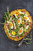 Blumenkohl-Pizza mit Spargel, Eiern, Speck und Erbsen