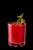 Hot raspberries and orange winter drink with cinnamon and rosemary isolated on black