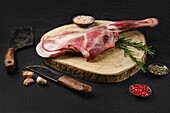Leg of lamb with rosemary and spices on wooden board