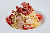 Spaghetti carbonara with ham, bacon and cherry tomatoes