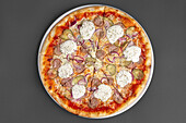 Pizza mit Wurst, Essiggurken, Zwiebeln und Sahnemeerrettich