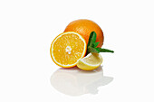 Whole and halved orange with lemon wedge and mint