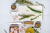 Chopping board with fresh thyme, spices and oil for seasoning marinade