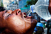Man drinking water in heatwave, Bangladesh