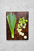 Whole and sliced leek on a chopping board