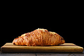 A croissant on a wooden board