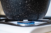 Pot on gas hob with blue flame
