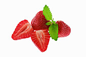 Whole and sliced strawberries with mint leaf
