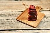 Stacked slices of smoked venison and beef salami