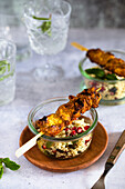 Chicken tandoori skewers on couscous salad with pomegranate seeds