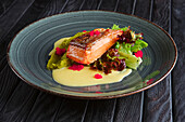 Fried salmon fillet with leaf salad and cream sauce