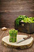 Green beans with knife on wooden cutting board