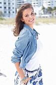 Young woman wearing a denim jacket, a white shirt and blue and white patterned trousers