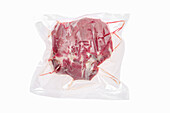 Vacuum-packed lamb neck on a white background