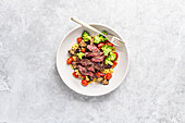 Gegrilltes Steak auf Gerstensalat mit Brokkoli und Tomaten