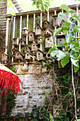 Vogelnistkästen aus Holz an einer Gartenwand mit Efeubewuchs