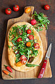 Pinsa Romana with rocket, cherry tomatoes and spring onions