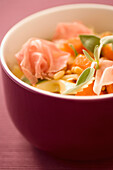 Pasta salad with ham and pine nuts