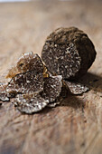 Sliced black truffle on a wooden board