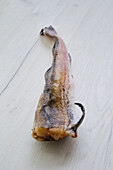 Frozen raw pollock carcass on wooden background