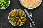 Grape leaves stuffed with meat and rice, traditional dolma on black background