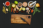 Various spices and herbs with chopping board