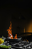 Pan with a blazing flame on a gas hob
