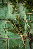bunch of rosemary on green tiles