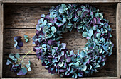 Summer flower wreath of blue hydrangeas (Hydrangea) in a wooden box