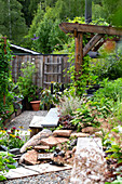 Grüner Garten mit Holzpergola und Kiesweg