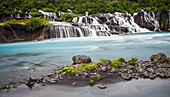 Hraunfossar Waterfalls flowing from lava rock field with lush vegetation, Borgarfjordodur, Iceland