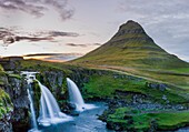 Island, Westliche Region, Grundafjordur, Kirkjufell und Kirkjufellsfoss Wasserfälle bei Sonnenuntergang