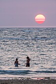 Frankreich, Charente Maritime, Insel Oleron, junge Frauen am Strand bei Sonnenuntergang