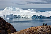 Grönland, Westküste, Diskobucht, Ilulissat, von der UNESCO zum Weltnaturerbe erklärter Eisfjord an der Mündung des Sermeq-Kujalleq-Gletschers (Jakobshavn-Gletscher), Wanderung auf dem Gelände von Sermermiut und Fischerboot am Fuße der Eisberge
