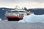 Grönland, Nordwestküste, Baffinsee, Inglefield Fjord in Richtung Qaanaaq, Eisberg und das Kreuzfahrtschiff MS Fram von Hurtigruten