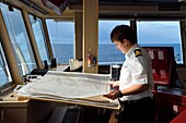 Grönland, Nordwestküste, Baffin Bay, die Navigationsoffizierin Maja Sabolic vom Hurtigruten Kreuzfahrtschiff MS Fram studiert die Karte