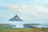 France, Manche, the Mont-Saint-Michel, view of the island and the abbey at sunrise from the mouth of the Couesnon river