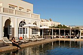 Morocco, Western Sahara, Dakhla, young Moroccan women on deckchairs in front of the swimming pool of Hotel Calipau