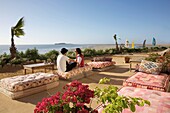 Marokko, Westsahara, Dakhla, marokkanisches Paar auf der Terrasse des Hotels PK25 vor dem Hintergrund einer Lagune