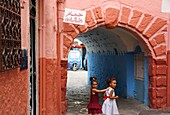 Marokko, Tanger Region Tetouan, Tanger, Marokkanische Mädchen in Kleidern in einer bunten Gasse in der Medina