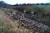 Frankreich, Eure, Cocherel, Allied Reconstitution Group (Verein zur historischen Rekonstruktion des Zweiten Weltkriegs und des französischen Maquis), Reenactors in Uniform der 101. US-Luftlandedivision, die sich entlang einer Eisenbahnlinie bewegen