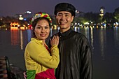 Vietnam, Hanoi, Old Town, Huc Bridge on Hoan Kiem Lake (Restored Sword Lake) and Ngoc Son pagoda (temple of the Jade Mountain), Vietnamese couple in traditional dress