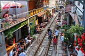 Vietnam, Hanoi, Eisenbahnlinie mitten durch die Altstadt, Touristen warten auf einen vorbeifahrenden Zug