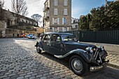 France, Paris, Montmartre, Citroën Traction Avant car on a paved street and in the background of the 2 CV Citröen