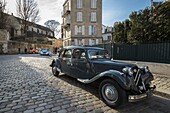 Frankreich, Paris, Montmartre, Citroën Traction Avant Auto auf einer gepflasterten Straße und im Hintergrund der 2 CV Citröen