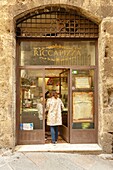 Italy, Tuscany, San Gimignano, woman entering a pizzeria