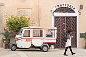 Italy, Basilicata, Matera, European Capital of Culture 2019, Piazza del Sedile, front of a trattoria and an Ape (Piaggio minivan motorbike) in the foreground